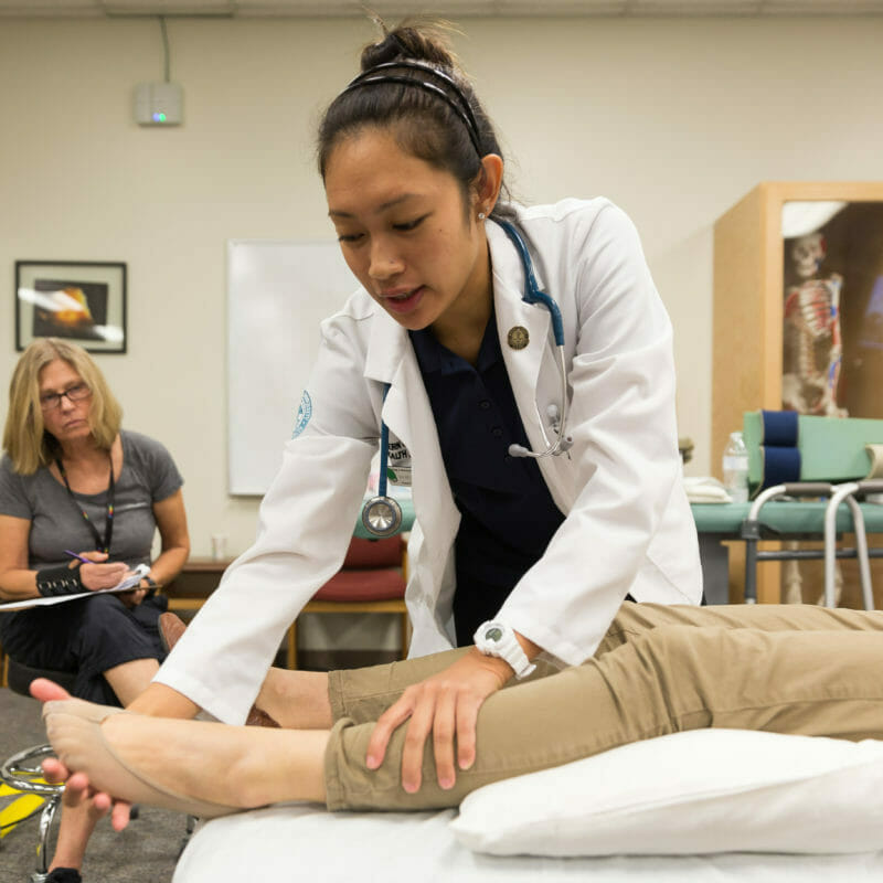 Student working with patient's legs