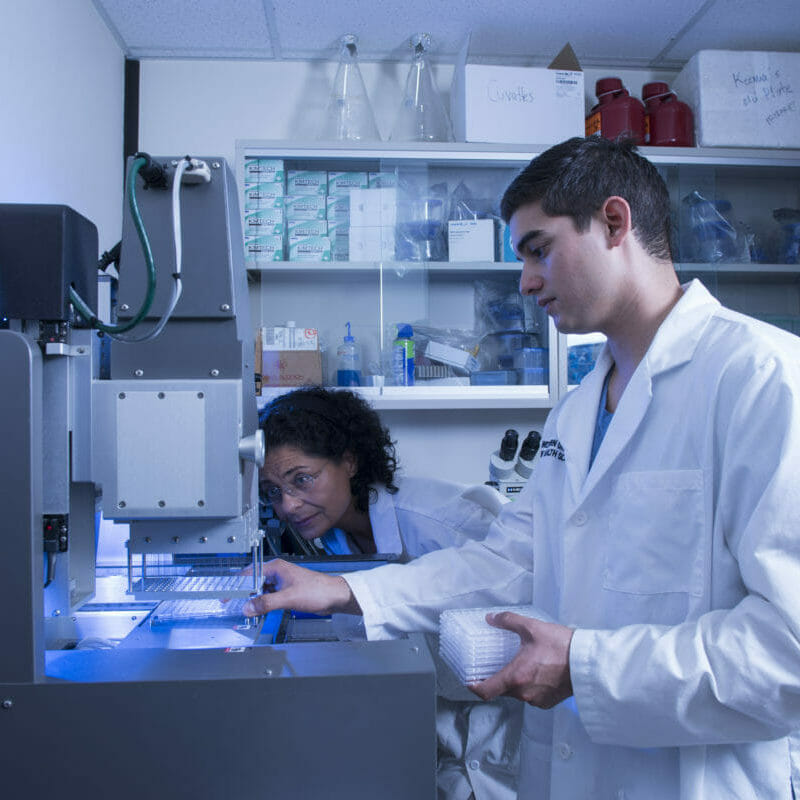Graduate College of Biomedical Sciences at Western University of Health Sciences poses oe works with a crystilzation robot in her lab
