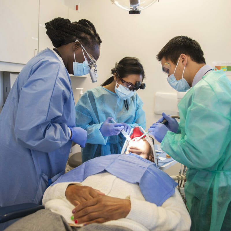 Woman receives dental care and treatment from Western University of Health Sciences’ College of Dental Medicine students Melanie Villalobos and Ben Nguyen, DMD ’15, along with supervising assistant professor Effuah Harris, DDS, at the Dental Center.
